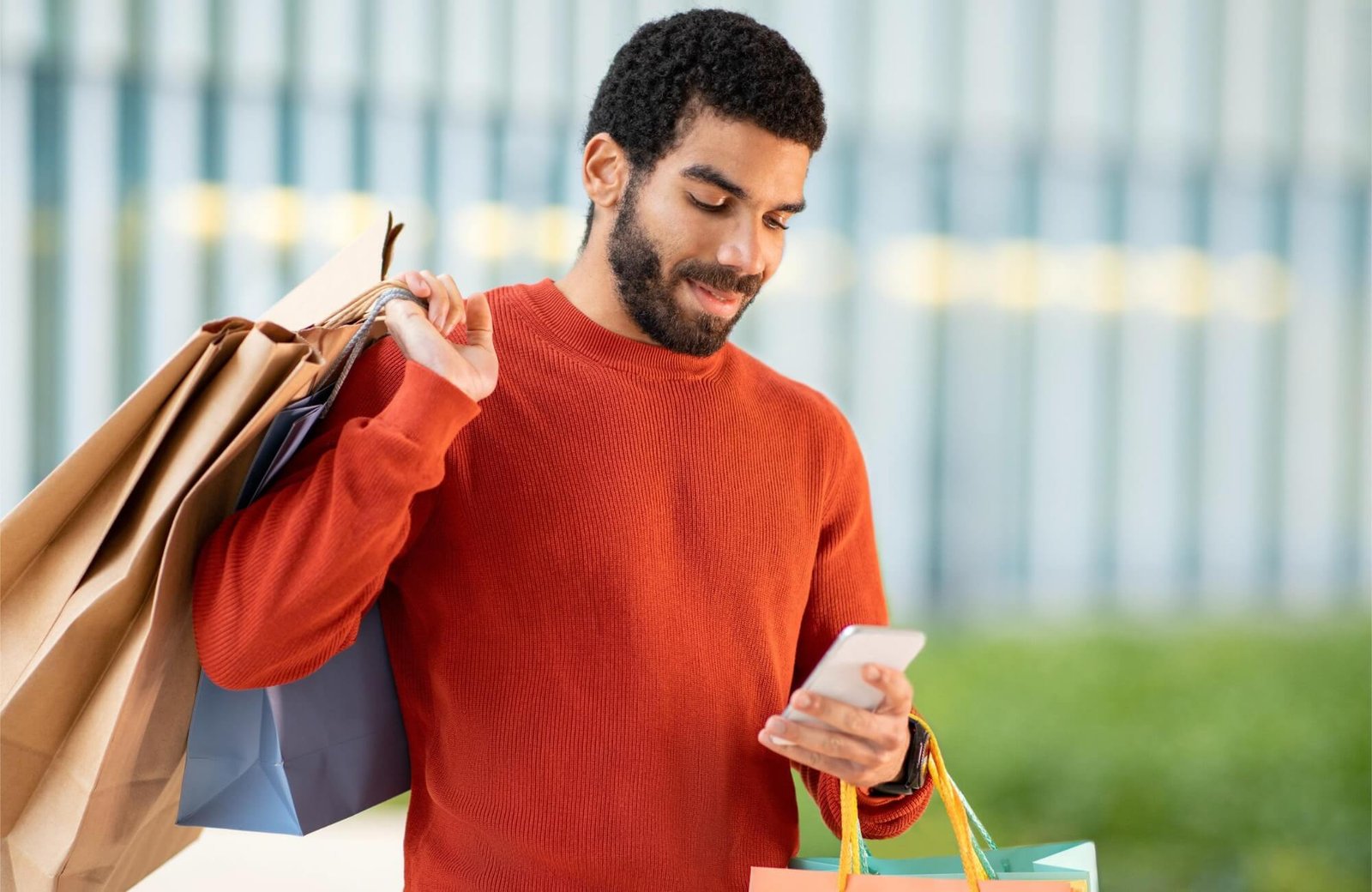 arabic-male-customer-using-phone-shopping-holding-89JAUS6.jpg