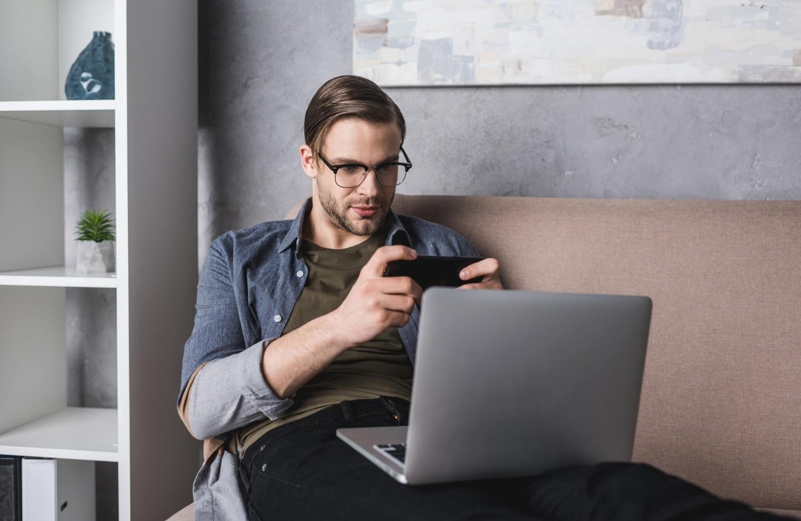 young-freelancer-with-laptop-on-knees-sitting-on-c-BYAGE5L.jpg